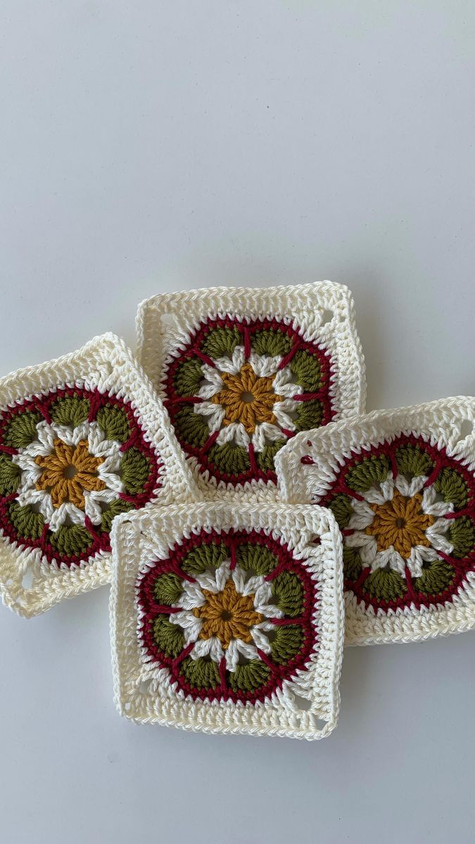 four crocheted coasters with flowers on them