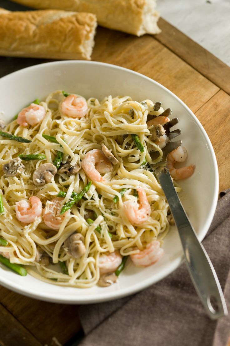 a white bowl filled with pasta and shrimp