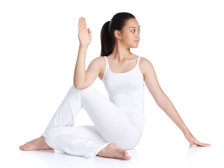 a woman is sitting on the floor with her arms in the air and looking up