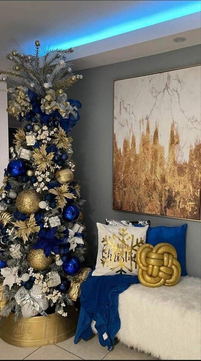 a blue and gold christmas tree in a living room