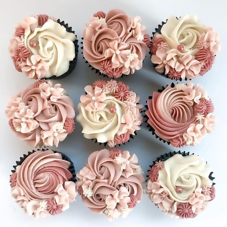 twelve cupcakes with pink and white frosting flowers on each one are arranged in a circle