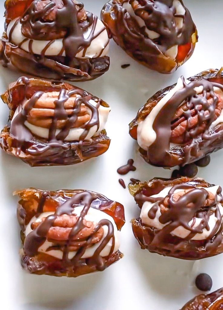 chocolate covered desserts are arranged on a white surface