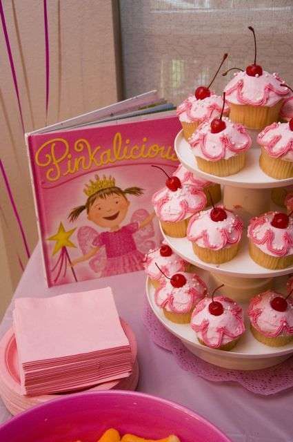 cupcakes and other dessert items on a table with a princess book in the background