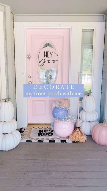 the front porch is decorated with white and pink pumpkins