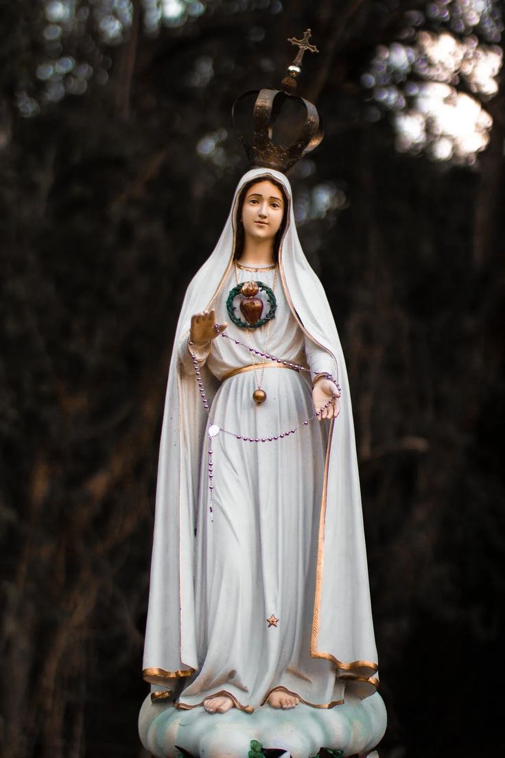 a statue of the virgin mary holding a cross