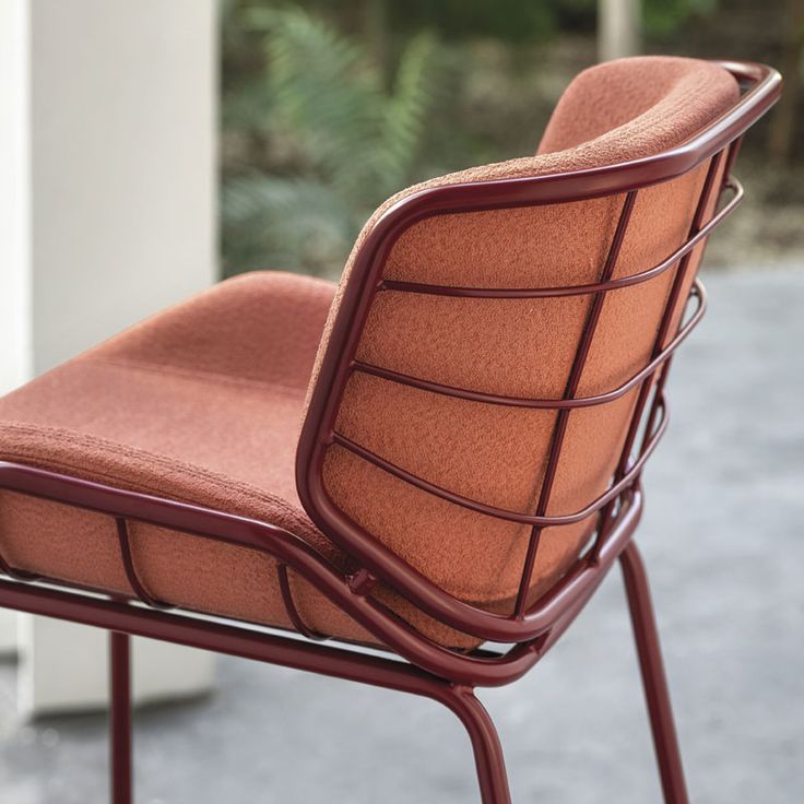 an orange chair sitting on top of a metal frame