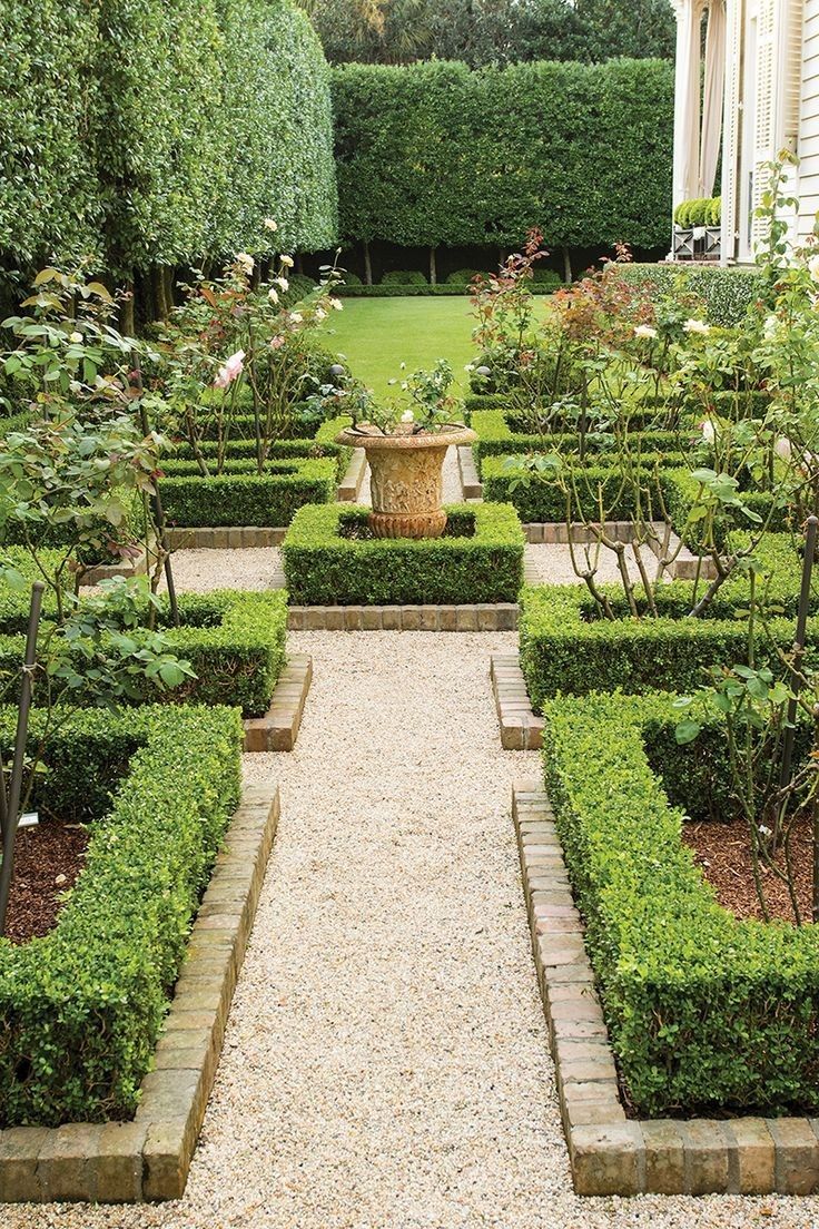 a formal garden is shown in the middle of a graveled area with trees and shrubs