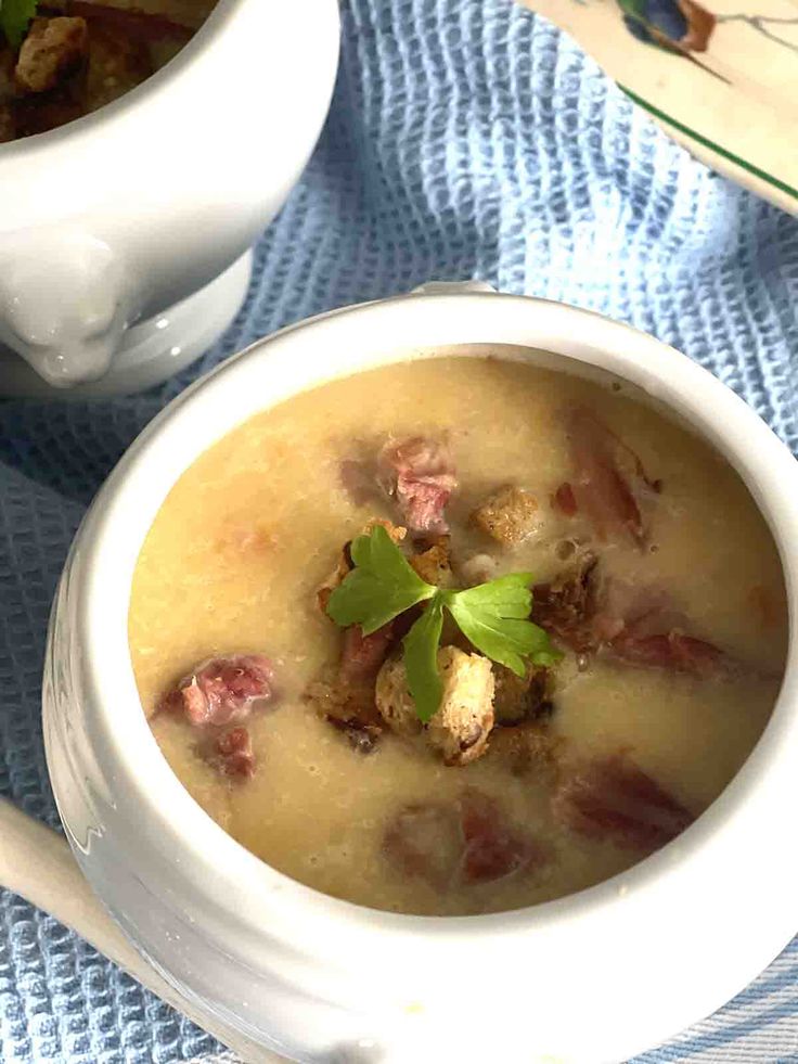 two white bowls filled with soup on top of a blue table cloth