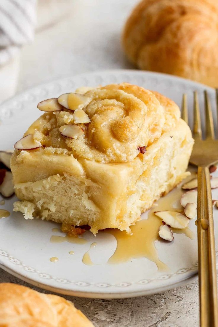 a piece of cake sitting on top of a white plate next to a golden fork