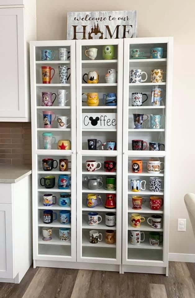 a white bookcase filled with lots of coffee mugs