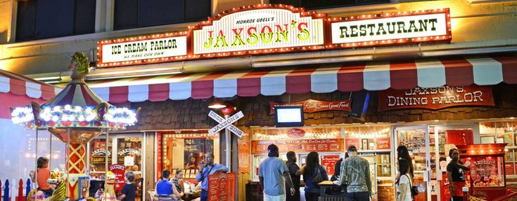 people are standing in front of a restaurant at night