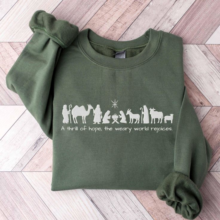 Celebrate the true meaning of Christmas with this beautifully embroidered Christian Christmas sweatshirt, perfect for the holiday season. Featuring a minimalist nativity scene silhouette and the powerful lyrics, "With a thrill of hope, the weary world rejoices," this soft and cozy green sweatshirt captures the essence of hope and joy found in the birth of Christ. Ideal for church gatherings, family celebrations, or simply spreading the message of peace, this Christmas sweatshirt is a meaningful Christian Christmas Svg, The Weary World Rejoices, Weary World Rejoices, Diy Christmas Shirts, A Thrill Of Hope, Thrill Of Hope, V Neck Shirts, Christmas Jesus, Christian Sweatshirt