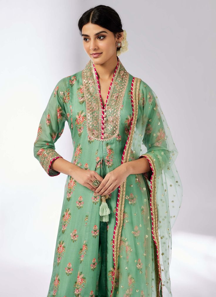 Elevate your style with this delicately embroidered ensemble that adds shimmer and richness. The long-sleeved, front-open kurta in luxurious cotton silk pairs beautifully with linen satin palazzo pants and a sheer net dupatta. Easy to carry and perfect for any occasion, this set effortlessly blends elegance with versatility.