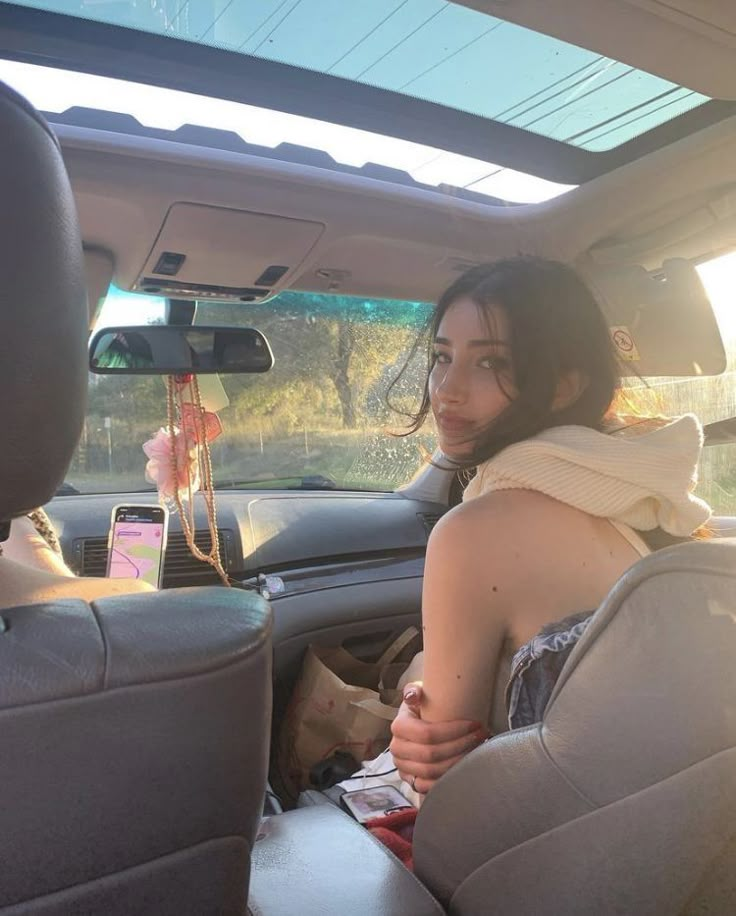 a woman sitting in the back seat of a car