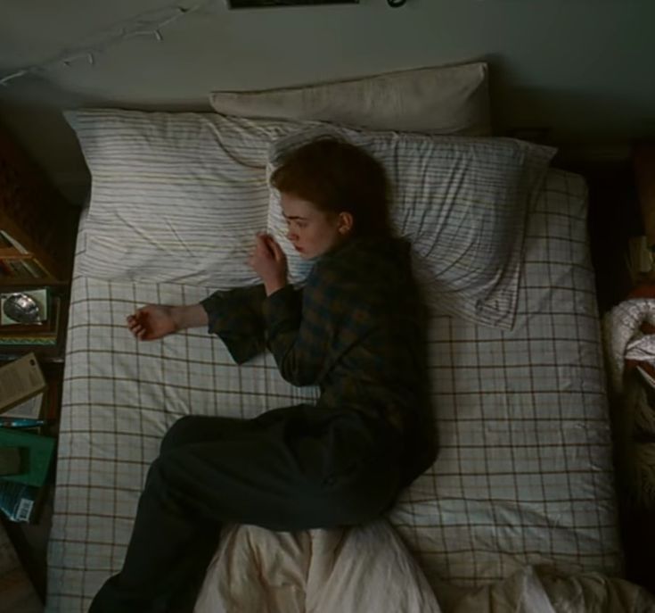 a boy laying in bed with his hand up