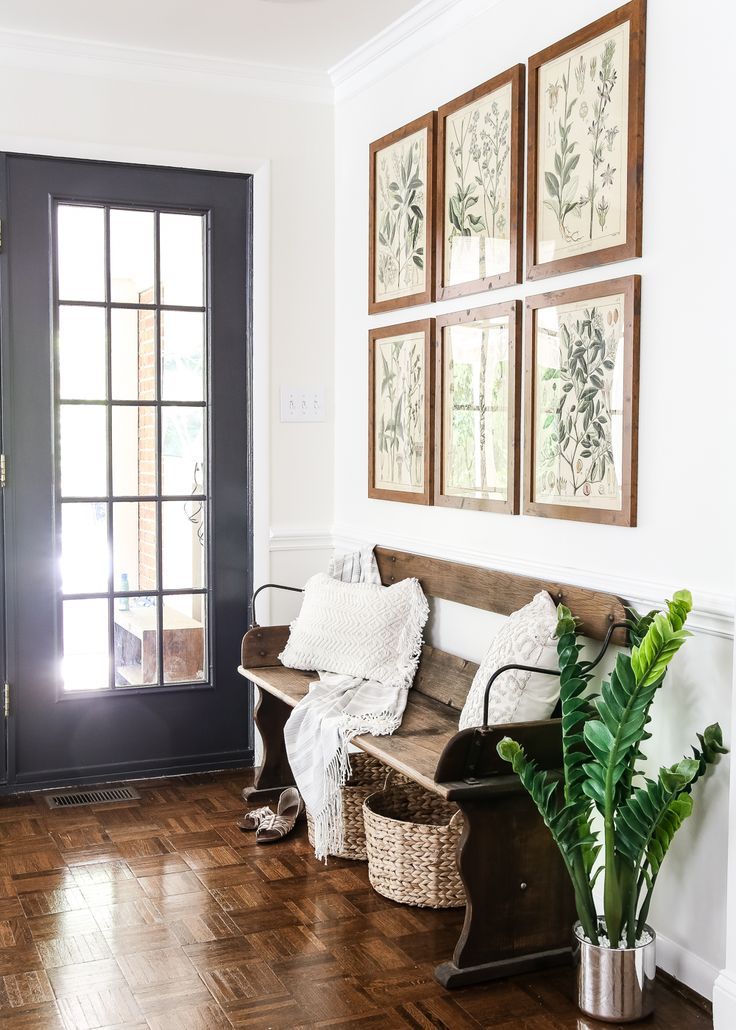 a wooden bench sitting on top of a hard wood floor next to a black door