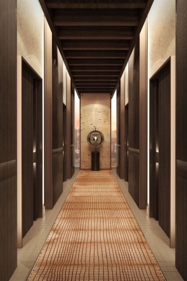 an empty hallway with tiled flooring and metal doors leading to the clock on the wall