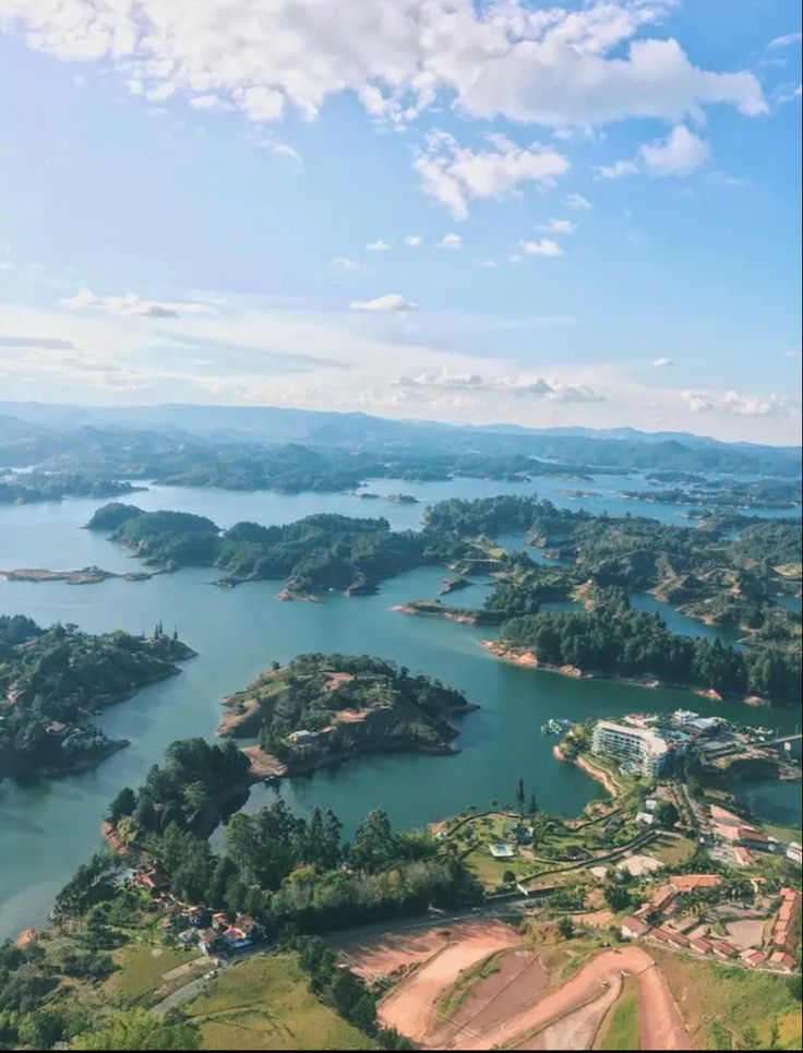 an aerial view of a lake surrounded by trees and land with lots of water in the distance