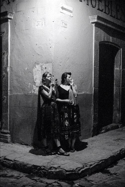 two women standing in front of a building talking on their cell phones with the caption'mueres de la via galaante '