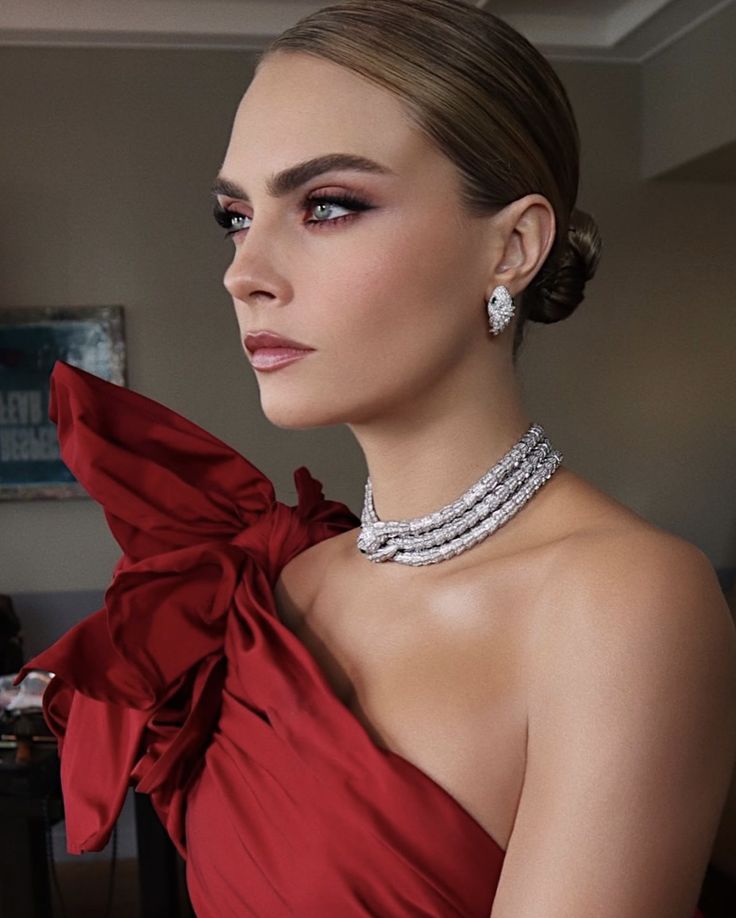 a woman in a red dress with jewelry on her neck