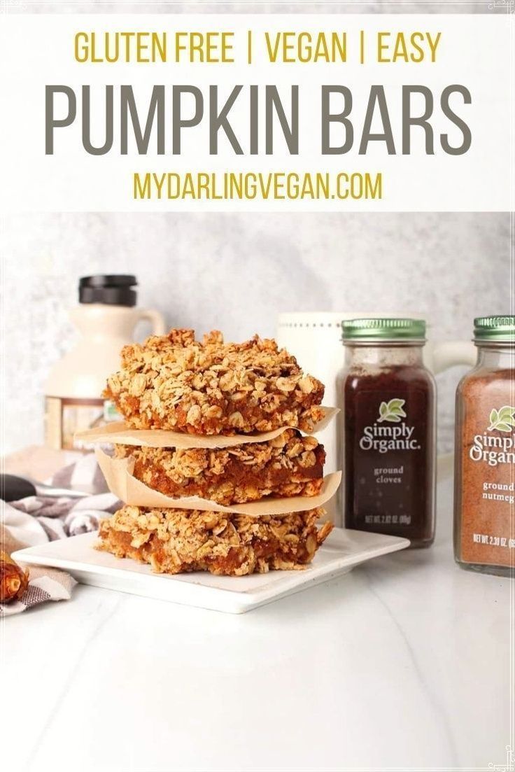 gluten free vegan bars stacked on top of each other with pumpkin sauce in the background