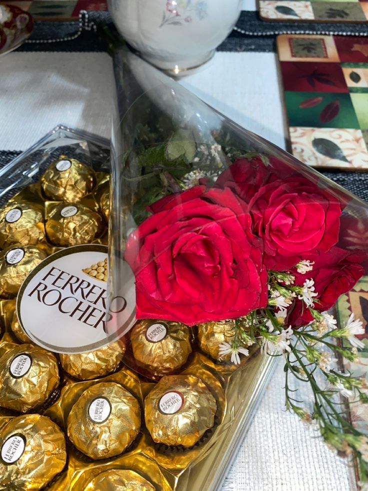 a bouquet of roses and chocolates on a table