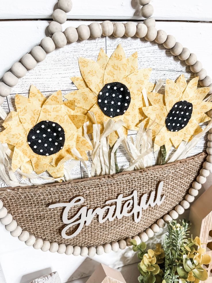 a wreath with sunflowers and the word grateful on it, surrounded by other decorations