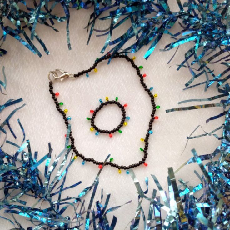 a beaded necklace is laying on some tinsel