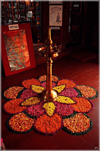 a candle is lit in the center of a flowered floor mat with flowers on it