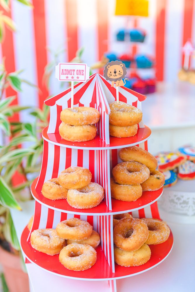 donuts are stacked on top of each other in a red and white striped tower