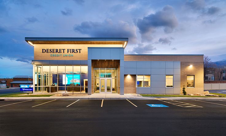 an empty parking lot in front of a desert first store at night with the lights on