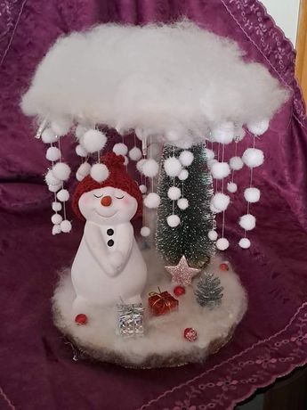 there is a snowman under the white cloud on this table top with christmas decorations