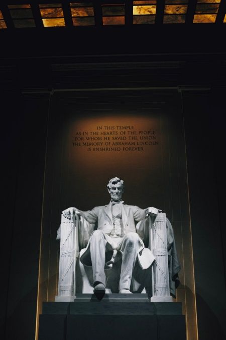 the lincoln memorial is lit up at night and has a statue of abraham lincoln on it