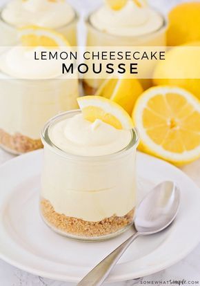 lemon cheesecake mousse in small glass jars on a plate with spoons