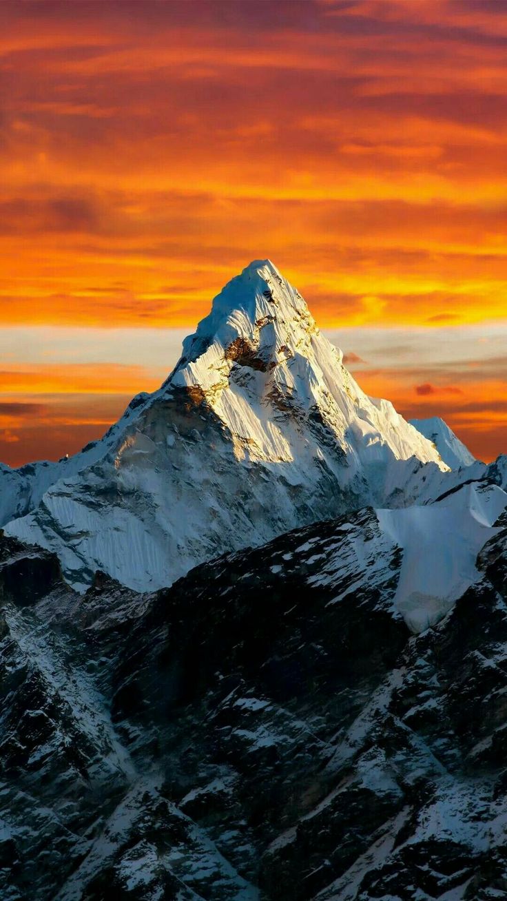 a snow covered mountain under a colorful sky