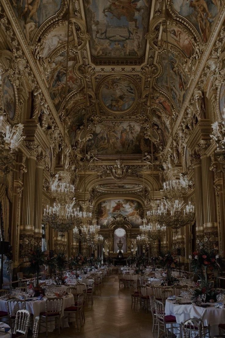 an ornately decorated dining hall with chandeliers and tables set for formal function