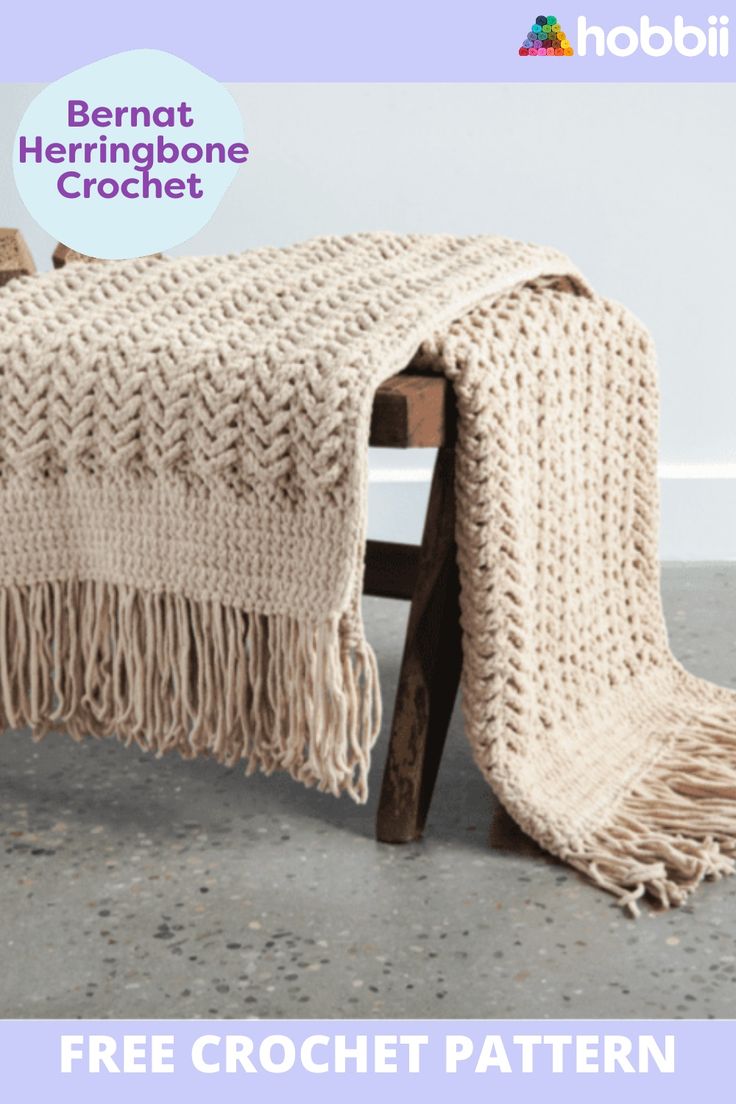 a crocheted blanket sitting on top of a wooden bench