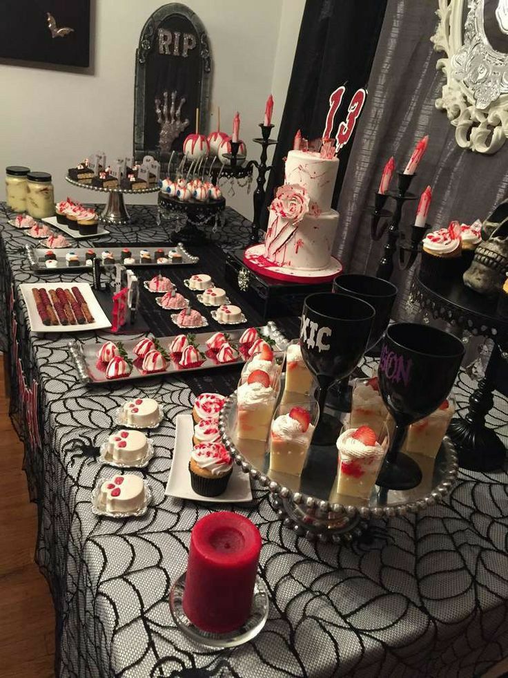 a table topped with cakes and cupcakes on top of a black table cloth