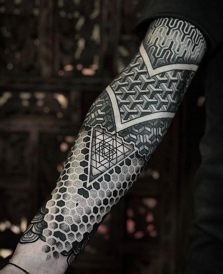 a man's arm with an intricate tattoo design on the forearm and hand area