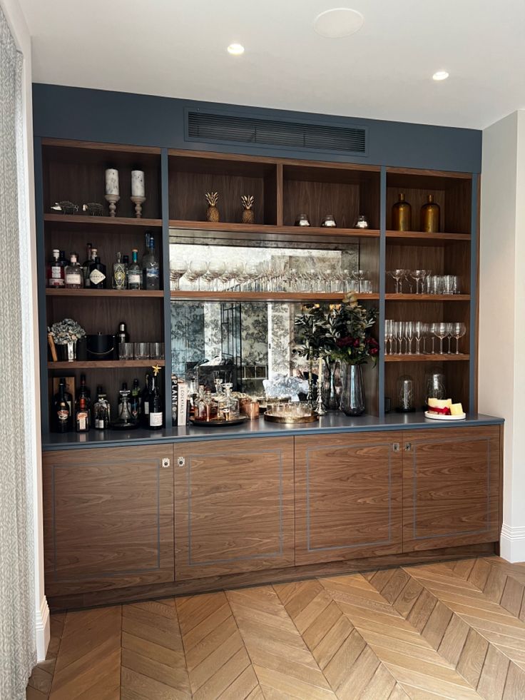 an empty bar with lots of bottles and glasses on the shelves in front of it