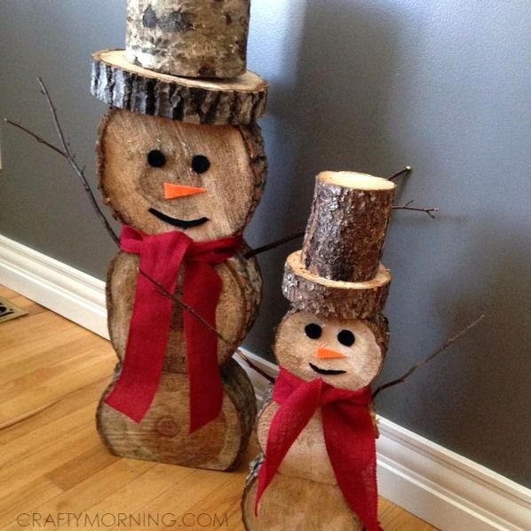 two snowmen made out of logs on the floor