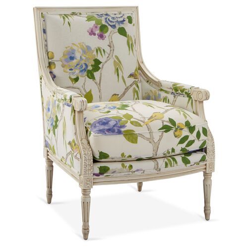 an upholstered chair with flowers and leaves painted on the back, sitting in front of a white background