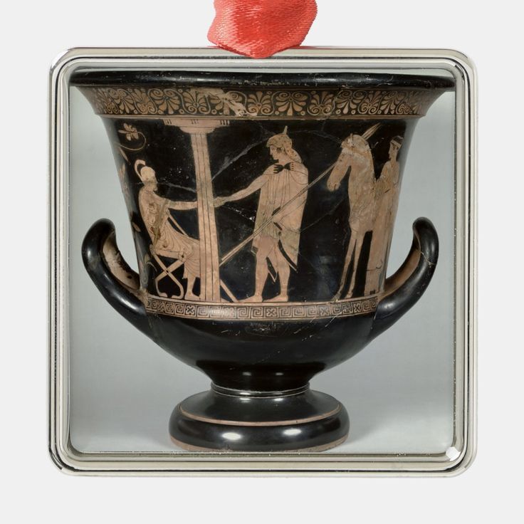 an ancient vase with figures on it and a red object in the middle of it