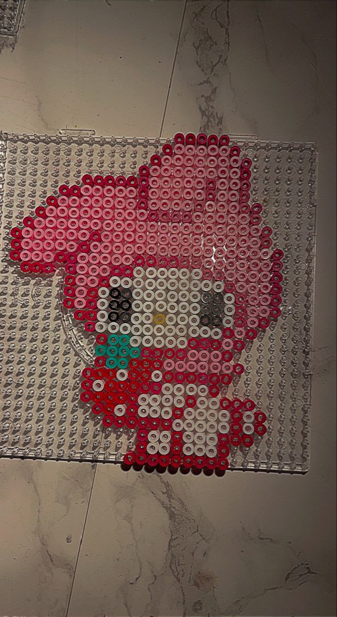 a hello kitty made out of legos is on the floor next to a wall