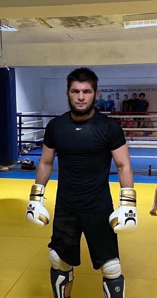 a man standing in a boxing ring with his hands on his hips wearing protective gear