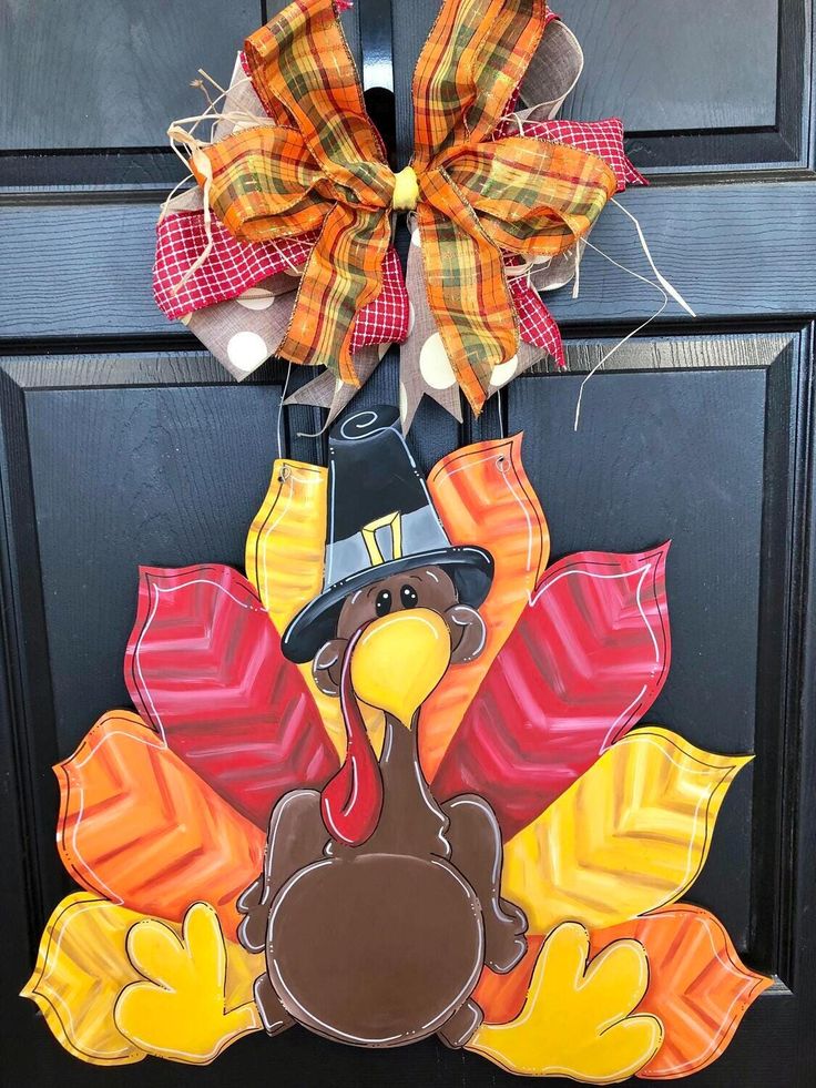 a door hanger with a turkey wearing a pilgrim hat