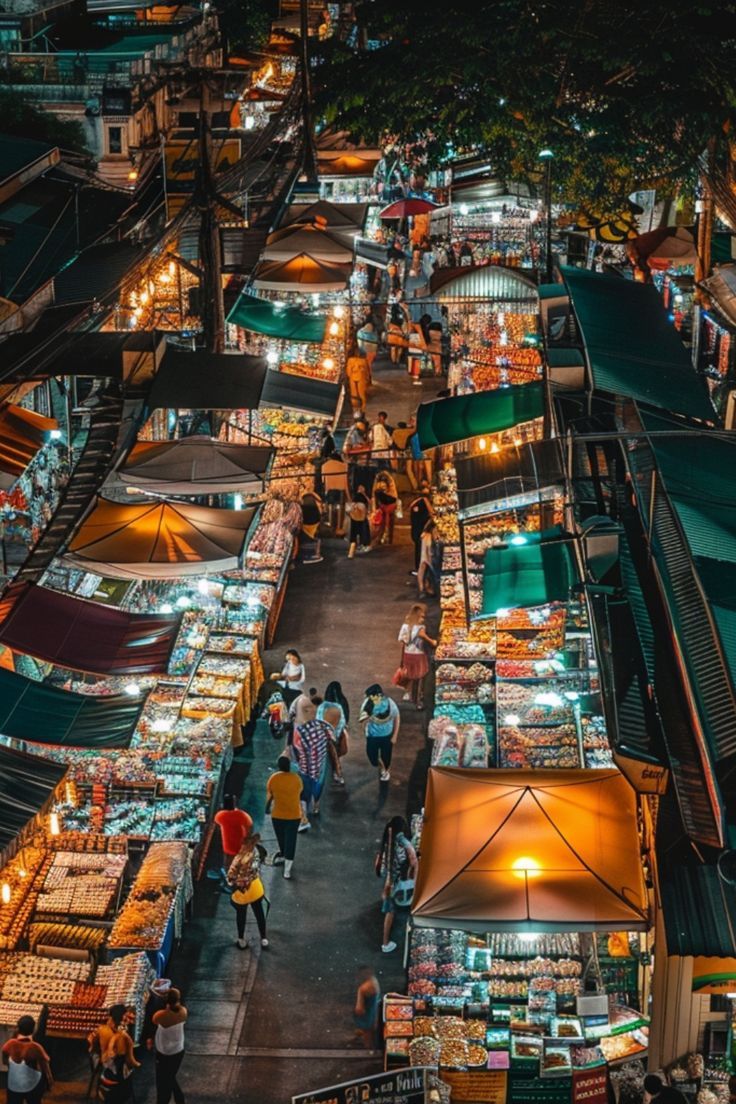 an aerial view of a market with people walking through it and vendors selling goods at night