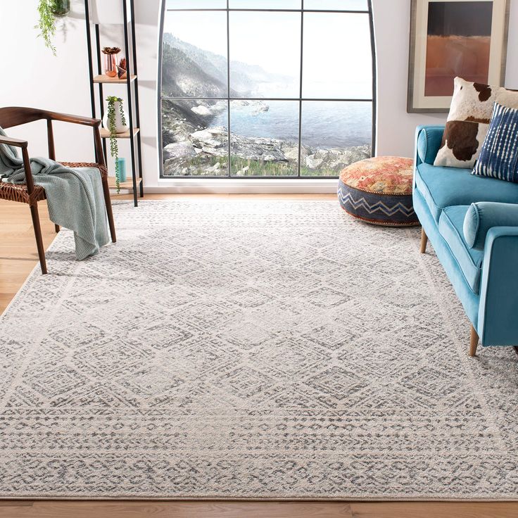 a living room with a blue couch and white rug on the floor next to a large window