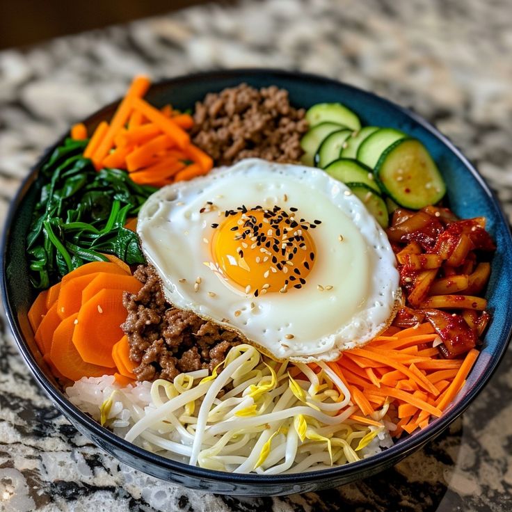 a bowl filled with meat, veggies and an egg on top of it