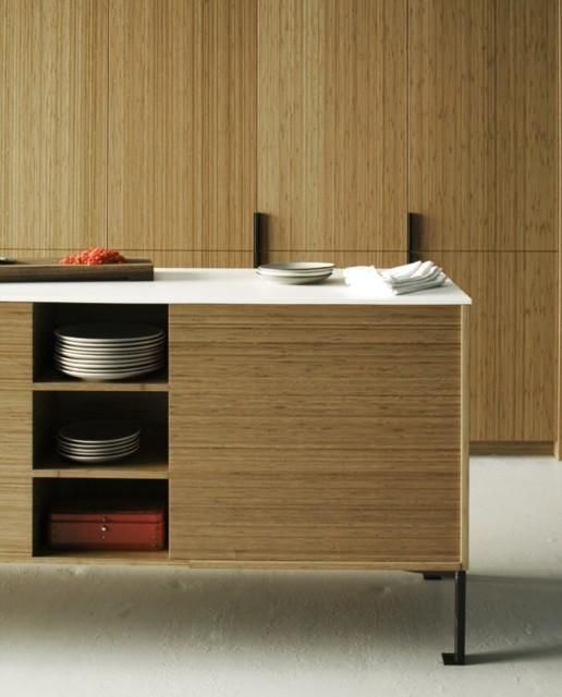 a kitchen with wooden cabinets and plates on the counter top, in front of an oven